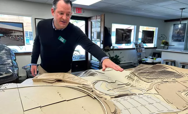 Theodore Roosevelt Presidential Library Foundation CEO Ed O'Keefe gestures to a model of the library and surrounding landscape at the library's office in Medora, N.D., Tuesday, Oct. 7, 2025. (AP Photo/Jack Dura)