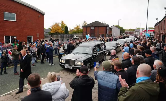 The hearse stops outside Hatton's Gym in Hyde, during a procession, ahead of a funeral service for former boxing champion Ricky Hatton at Manchester Cathedral, England, Friday Oct. 10, 2025. (Owen Humphreys/PA via AP)