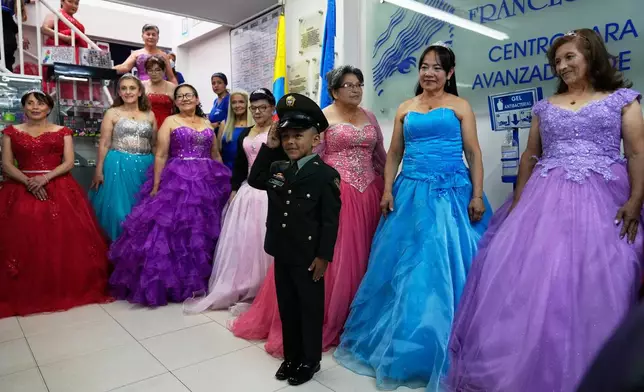 A boy escorts Rosalba Casas, right, and other women who never had a traditional 15th birthday party during a quinceanera celebration organized by the Suenos Hechos foundation in Bogota, Colombia, Friday, Oct. 24, 2025. (AP Photo/Fernando Vergara)