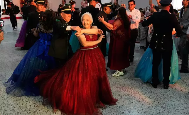 Mariela Diaz, 73, dances a waltz during a quinceanera celebration for women who never had a traditional 15th birthday party, organized by the Suenos Hechos foundation in Bogota, Colombia, Friday, Oct. 24, 2025. (AP Photo/Fernando Vergara)