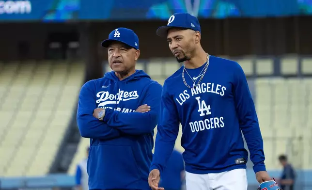 Los Angeles Dodgers manager Dave Roberts, left, talks with Mookie Betts during practice Tuesday, Oct. 7, 2025, in Los Angeles, the day before Game 3 of baseball's National League Division Series against the Philadelphia Phillies. (AP Photo/Jae C. Hong)