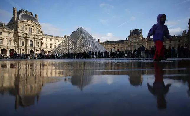 People queue to enter Le Louvre museum Monday, Oct. 27, 2025 in Paris. (AP Photo/Christophe Ena)