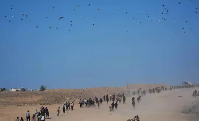 Displaced Palestinians walk toward Gaza City, in the northern Gaza Strip, Friday, Oct. 10, 2025, after Israel and Hamas agreed to a pause in their war and the release of the remaining hostages. (AP Photo/Jehad Alshrafi)