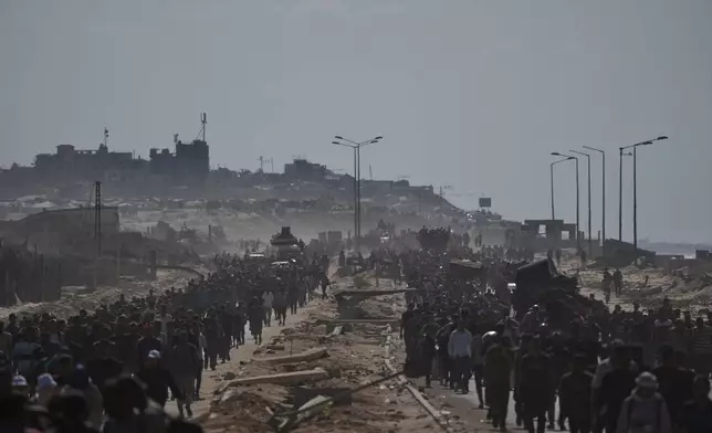 Displaced Palestinians walk with their belongings along the coastal road near Wadi Gaza in the central Gaza Strip, moving toward Gaza City, Friday, Oct. 10, 2025, after Israel and Hamas have agreed to a pause in their war and the release of the remaining hostages. (AP Photo/Abdel Kareem Hana)