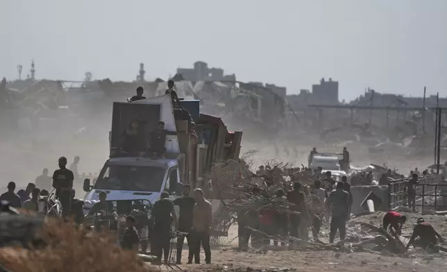 Displaced Palestinians load their belongings onto trucks as they return to Gaza City, in the northern Gaza Strip, Friday, Oct. 10, 2025, after Israel and Hamas agreed to a pause in their war and the release of the remaining hostages. (AP Photo/Jehad Alshrafi)