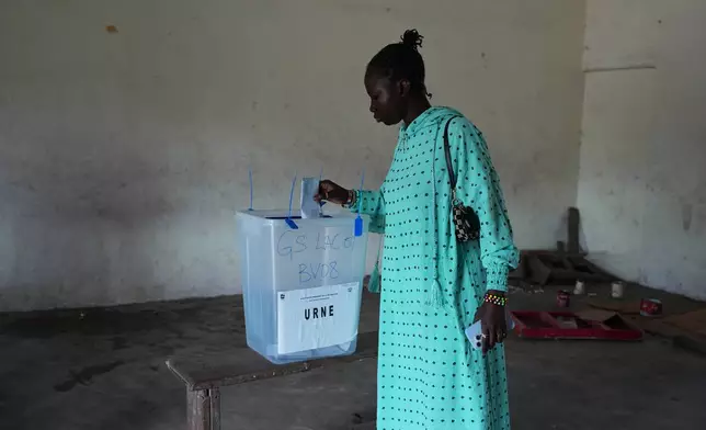 A woman casts her vote at a polling station during the presidential elections in Abidjan, Ivory Coast, Saturday, Oct. 25, 2025. (AP Photo/Misper Apawu)