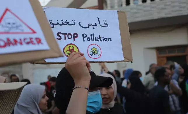 People take part in a demonstration against pollution caused by chemical factories, in Gabes, Tunisia, Wednesday, Oct. 16, 2025. Banner in Arabic reads "Gabes is suffocating." (AP Photo/Bassem Aouini)