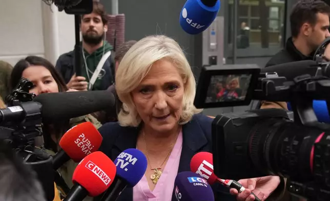 French far right leader Marine Le Pen talks to the media following a meeting at the National Rally party headquarters, after France's prime minister Sebastien Lecornu resigned plunging the country into a deep political crisis. Monday, Oct. 6, 2025 in Paris. (AP Photo/Christophe Ena)