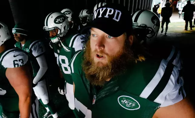 FILE - New York Jets center Nick Mangold (74) wears an NYPD hat as he waits to go on the field for the start of an NFL football game against the New England Patriots, Sunday, Dec. 21, 2014, in East Rutherford, N.J. (AP Photo/Julio Cortez, File)