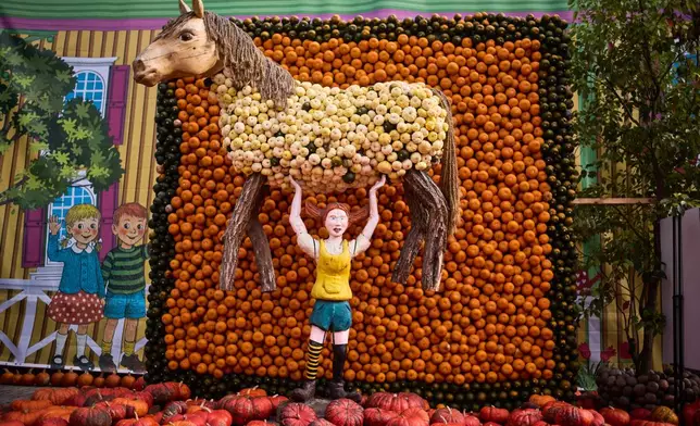 A pumpkin sculpture depicting fictional Swedish book character Pippi Longstocking, is displayed at Klaistow farm’s annual pumpkin festival, which this year celebrates “powerful women,” in Beelitz near Berlin, Germany, Tuesday, Oct. 21, 2025. (AP Photo/Markus Schreiber)