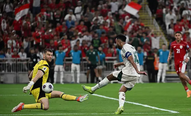 Saudi Arabia's Salem Al Dawsari, right, attempts a shot at goal in front of Indonesia's goalkeeper Maarten Vincent Paes during the World Cup 2026 Asian qualifier fourth-round Group B soccer match between Saudi Arabia and Indonesia at Alinma Bank Stadium in King Abdullah Sports City, in Jiddah, Saudi Arabia, Wednesday, Oct. 8, 2025. (AP Photo)