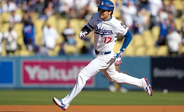 Los Angeles Dodgers' Shohei Ohtani rounds the bases after a triple against the Milwaukee Brewers during the first inning in Game 3 of baseball's National League Championship Series, Thursday, Oct. 16, 2025, in Los Angeles. (AP Photo/Ashley Landis)