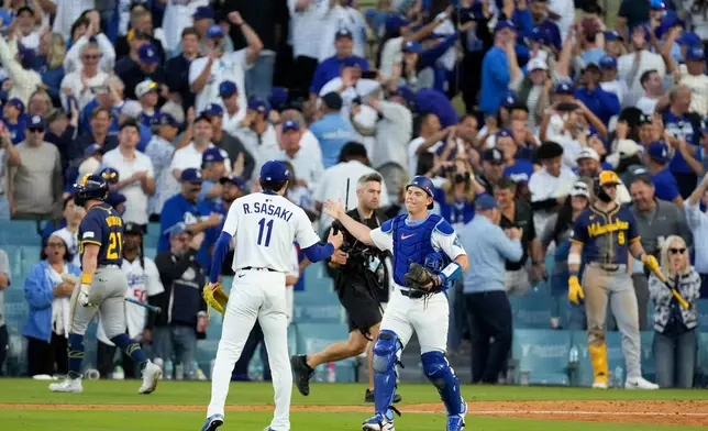 Los Angeles Dodgers pitcher Roki Sasaki and catcher Will Smith celebrate their win against the Milwaukee Brewers in Game 3 of baseball's National League Championship Series, Thursday, Oct. 16, 2025, in Los Angeles. (AP Photo/Mark J. Terrill)