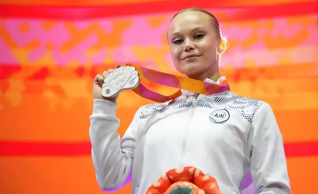Silver medal winner, Individual Neutral Athlete Angelina Melnikova poses on the podium after competing in the women's uneven bars final during the 53rd Artistic Gymnastics World Championships in Jakarta, Indonesia, Friday, Oct. 24, 2025. (AP Photo/Dita Alangkara)