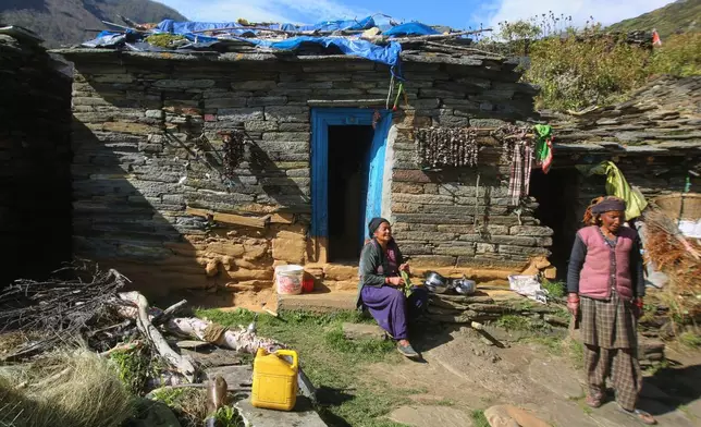 Nomi Devi, left, sits outside her house and chats with a neighbor in Laspa village, situated on the route of a trek to the Nanda Devi base camp in the northern Indian Himalayan state of Uttarakhand, on Sept. 28, 2025. (AP Photo/Satish Sharma)