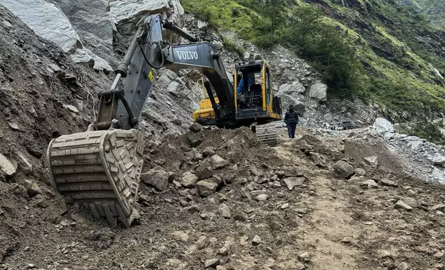 An earthmover clears a unpaved mountain road of debris near Laspa viallge, in the northern Indian Himalayan state of Uttarakhand, on Oct. 4, 2025. (AP Photo/Satish Sharma)