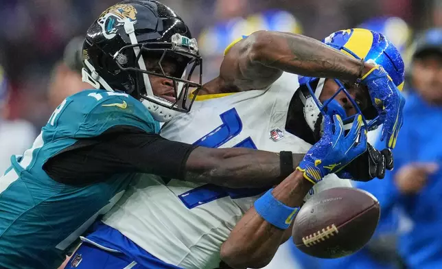 Los Angeles Rams wide receiver Davante Adams (17) is challenged by Jacksonville Jaguars wide receiver Travis Hunter (12) during the second half of an NFL football game between the Los Angeles Rams and the Jacksonville Jaguars in London, Sunday, Oct. 19, 2025. (AP Photo/Kin Cheung)