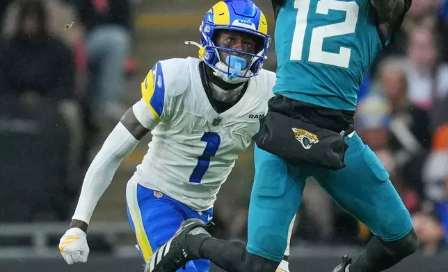 Jacksonville Jaguars wide receiver Travis Hunter (12) catches the ball as Los Angeles Rams Emmanuel Forbes Jr. closes in during the second half of an NFL football game between the Los Angeles Rams and the Jacksonville Jaguars in London, Sunday, Oct. 19, 2025. (AP Photo/Kin Cheung)
