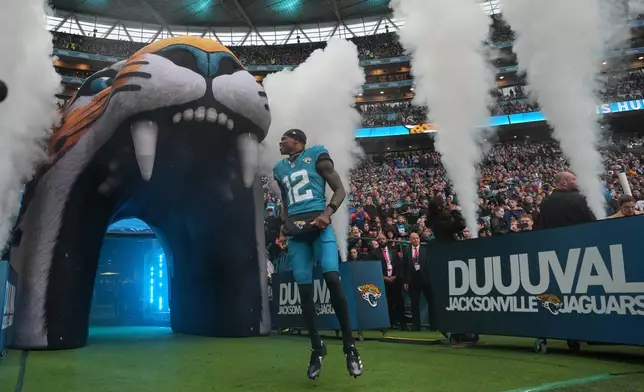 Jacksonville Jaguars wide receiver Travis Hunter (12) runs onto the field for an NFL football game between the Los Angeles Rams and the Jacksonville Jaguars in London, Sunday, Oct. 19, 2025. (AP Photo/Kin Cheung)