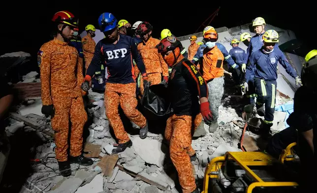 Rescuers bring down a body they recovered from the ruins of a collapsed building, Wednesday, Oct. 1, 2025 after a strong earthquake struck Bogo city, Cebu Province, Central Philippines. (AP Photo/Aaron Favila)