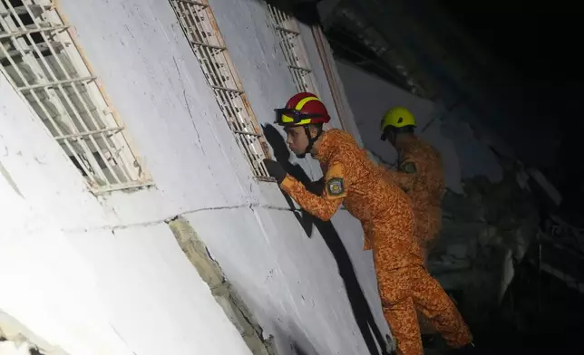 Rescuers check for survivors from the ruins of a collapsed building, Wednesday, Oct. 1, 2025 after a strong earthquake struck Bogo city, Cebu Province, Central Philippines. (AP Photo/Aaron Favila)