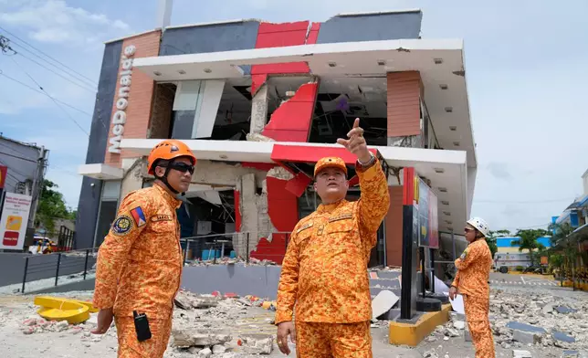 Firemen inspect outside a damaged restaurant on Thursday, Oct. 2, 2025 after Tuesday's strong earthquake in Bogo city, Cebu Province, Central Philippines. (AP Photo/Aaron Favila)