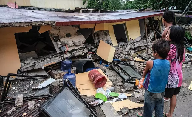 People look at a collapsed building in Bogo City, Cebu province, Philippines Wednesday, Oct. 1, 2025 after an offshore earthquake on late Tuesday. (AP Photo)