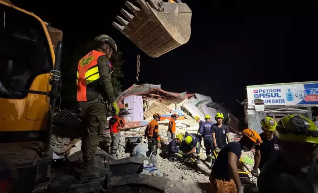 Rescuers search for survivors underneath rubble in Bogo city, Philippines, Wednesday, Oct. 1, 2025. (AP Photo/Aaron Favila)