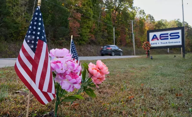 Flags and flowers are seen at the entrance to Accurate Energetic Systems Friday, Oct. 24, 2025, after an explosion killed 16 people on Oct. 10, in McEwen, Tenn. (AP Photo/George Walker IV)