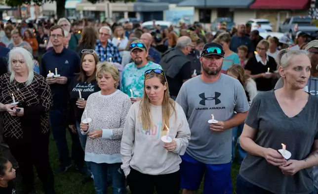 People attend a candlelight vigil at the Humphreys County Courthouse honoring the victims of a blast at an explosives plant, Accurate Energetic Systems, Sunday, Oct. 12, 2025, in Waverly, Tenn. (AP Photo/George Walker IV)