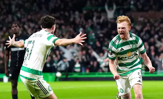 Celtic's Liam Scales, right, celebrates scoring their side's first goal of the game during the UEFA Europa League soccer match between Celtic Glasgow and Sturm Graz, in Glasgow, Scotland, Thursday Oct. 23, 2025. (Jane Barlow/PA via AP)