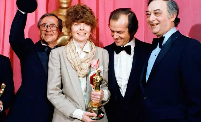 FILE - Oscar winners Charles H. Joffe, winner of best picture for "Annie Hall," left, and Diane Keaton, winner of best actress for "Annie Hall," poses with presenter Jack Nicholson, and producer Jack Rollins at the Academy Awards in Los Angeles on April 3, 1978. (AP Photo, File)