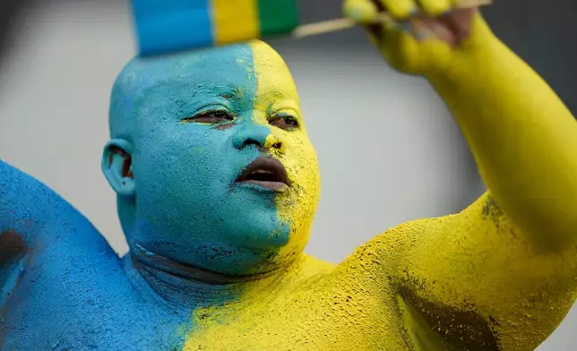 A fan of Rwanda waits for the start of a World Cup 2026 group C qualifying soccer match between South Africa and Rwanda at Mbombela Stadium, in Nelspruit, South Africa, Tuesday, Oct. 14, 2025. (AP Photo/Themba Hadebe)