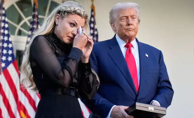 Erika Kirk wipes her eyes as a military aide reads the citation before President Donald Trump posthumously awards the Presidential Medal of Freedom to her late husband Charlie Kirk in the Rose Garden of the White House, Tuesday, Oct. 14, 2025, in Washington. (AP Photo/Mark Schiefelbein)