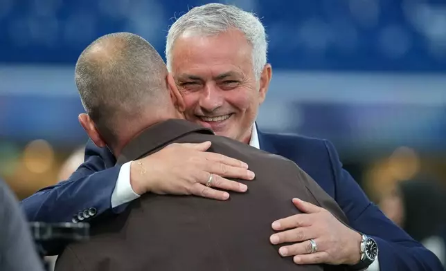 Benfica's head coach Jose Mourinho embraces former Chelsea player Joe Cole after giving an interview on the pitch ahead of a Champions League opening phase soccer match between Chelsea and SL Benfica at Stamford Bridge stadium in London, Tuesday, Sept. 30, 2025. (AP Photo/Kin Cheung)