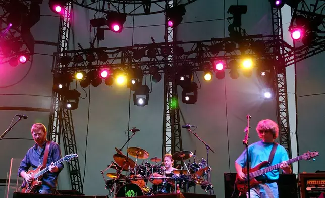 FILE - Phish's Trey Anastasio, left, drummer Jon Fishman, center, and bassist Mike Gordon perform with the band at Keyspan Park in the Brooklyn borough of New York Thursday, June 17, 2004. (AP Photo/Chad Rachman, File)