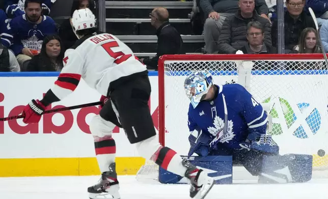 New Jersey Devils defenceman Brenden Dillon (5) scores past Toronto Maple Leafs goaltender Anthony Stolarz (41) during second period NHL hockey action in Toronto, Tuesday, Oct. 21, 2025. (Nathan Denette/The Canadian Press via AP)
