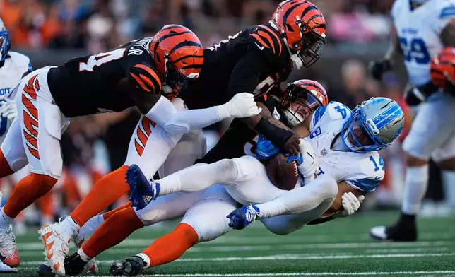 Detroit Lions wide receiver Amon-Ra St. Brown (14) is brought down by Cincinnati Bengals defenders during the second half of an NFL football game Sunday, Oct. 5, 2025, in Cincinnati. (AP Photo/Carolyn Kaster)