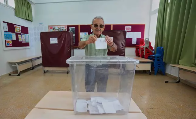 A man casts his ballot at a polling station during the Turkish Cypriot leadership election in the Turkish-occupied northern part of the divided capital Nicosia, Cyprus, Sunday, Oct. 19, 2025. (AP Photo/Petros Karadjias)
