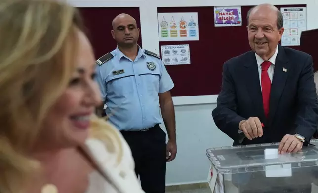 Turkish Cypriot candidate and leader Ersin Tatar, right, and his wife Sibel, cast their ballots at a polling station during the Turkish Cypriots election for a new leader in the Turkish occupied area in the north part of the divided capital Nicosia, Cyprus, Sunday, Oct. 19, 2025. (AP Photo/Petros Karadjias)