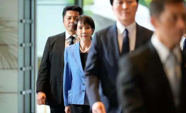 Japan's newly elected Prime Minister Sanae Takaichi, center, arrives at the prime minister's office in Tokyo, Japan, Tuesday, Oct. 21, 2025.(AP Photo/Eugene Hoshiko)