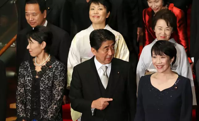 FILE - Japan's Prime Minister Shinzo Abe, front row center, and his new Cabinet members pose for a group photo following the first Cabinet meeting at the prime minister's official residence in Tokyo, Sept. 3, 2014. The ministers from the right front row are Internal Affairs Minister Sanae Takaichi, Abe, Trade Minister Yuko Obuchi, from the right second row, Minister in charge of Japanese Abducted by North Korea Eriko Yamatani, Minister in charge of Promoting Women Haruko Arimura, and Minister in charge of Economic Revitalization Akira Amari. At right top is Justice Minister Midori Matsushima. (AP Photo/Eugene Hoshiko, File)