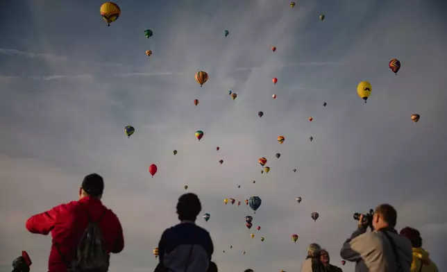 FILE - A crowd watches as hundreds of hot air balloons fill the morning sky over Albuquerque, N.M., on the second day of the Balloon Fiesta Oct. 3, 2021. (Adria Malcolm/The Albuquerque Journal via AP, File)