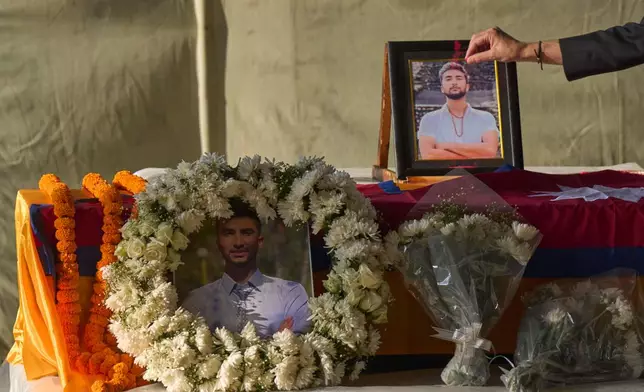 A Nepalese man pays his respects to Bipin Joshi, a Nepali man who was taken hostage by Hamas, during a memorial procession at Tribhuvan International Airport in Kathmandu, Nepal, Monday, Oct. 20, 2025. (AP Photo/Niranjan Shrestha)