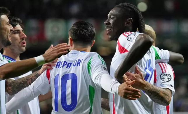 Italy's Moise Kean, right, celebrates with teammates after scoring the opening goal during a World Cup 2026 group I qualifying soccer match between Estonia and Italy in Tallinn, Estonia, Saturday, Oct. 11, 2025. (AP Photo/Sergei Grits)