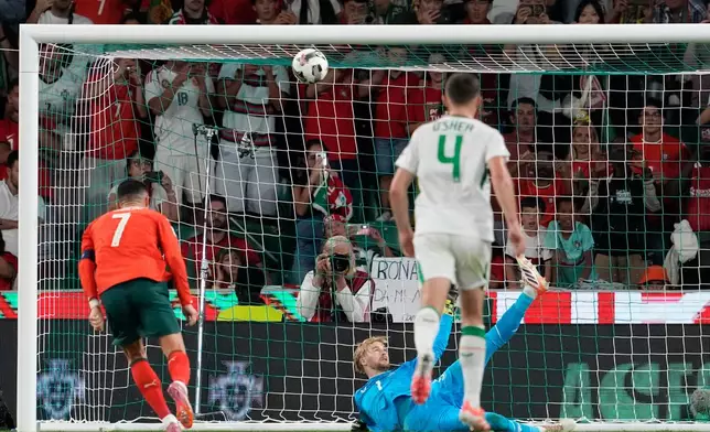 Caoimhin Kelleher goalkeeper of Ireland, bottom, saves a penalty kick from Portugal's Cristiano Ronaldo during a 2026 World Cup qualifying soccer match between Portugal and Ireland in Group F in Lisbon on Saturday, October 11, 2025. (AP Photo/Armando Franca)