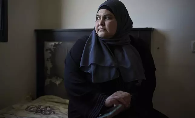 Rudeina Amouri, 42, holds a broken smartphone that belonged to her 13-year-old daughter, Rimas Amouri, who was killed during an Israeli raid while standing in the courtyard of their home, in the West Bank city of Jenin on April 21, 2025. (AP Photo/Leo Correa)