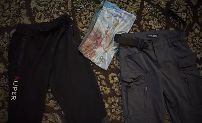 Blood-stained underwear and trousers, which Anwar al-Heimouni says were worn by her 12-year-old son, Ayman al-Heimouni, when he was killed by Israeli fire, are laid out for a picture in a room of their home in the West Bank city of Hebron, March 26, 2025. (AP Photo/Leo Correa)