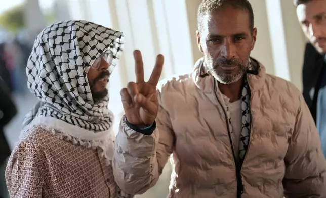 Activists from the Global Sumud Flotilla give the peace sign after arriving at Istanbul Airport in Istanbul, Turkey, Saturday, Oct. 4, 2025. (AP Photo/Khalil Hamra)