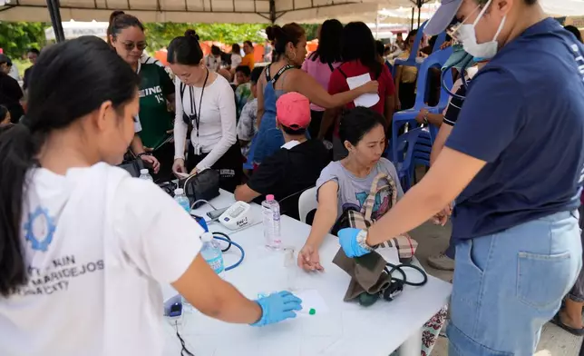 Survivors of Tuesday's earthquake get checked on Thursday, Oct. 2, 2025 in San Remigio, Cebu Province, Central Philippines. (AP Photo/Aaron Favila)